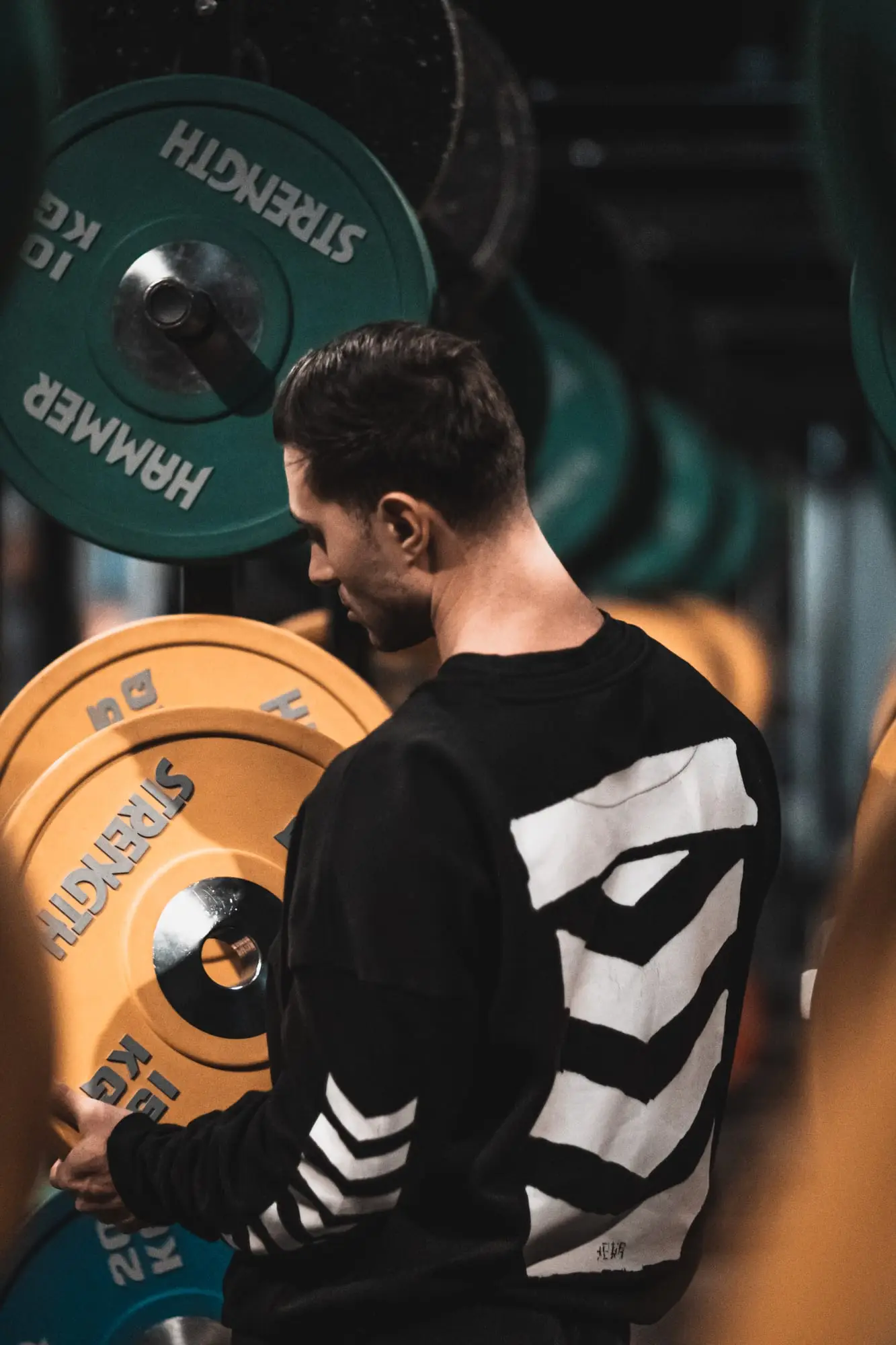 Novica Training: Athlet vor dem Hantelregal, Ausschnitt aus dem Fitness-Shooting